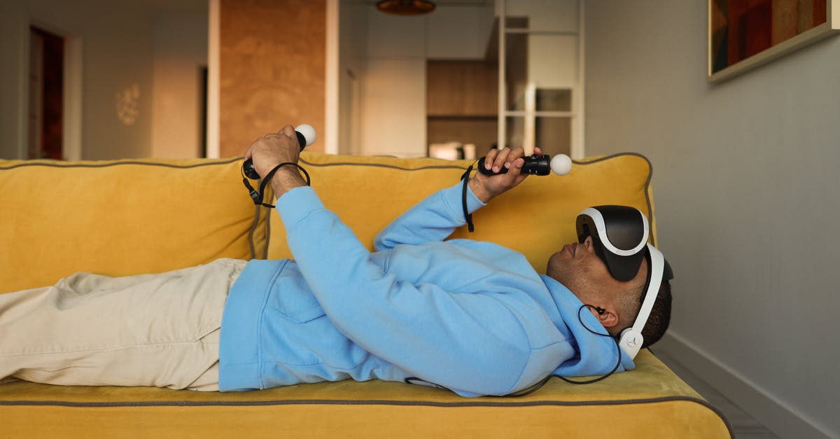 Oculus rift cv1 - some games are not displaying video in the headset - Man in Blue Hoodie Lying on Yellow Couch Wearing a Virtual Reality Headset