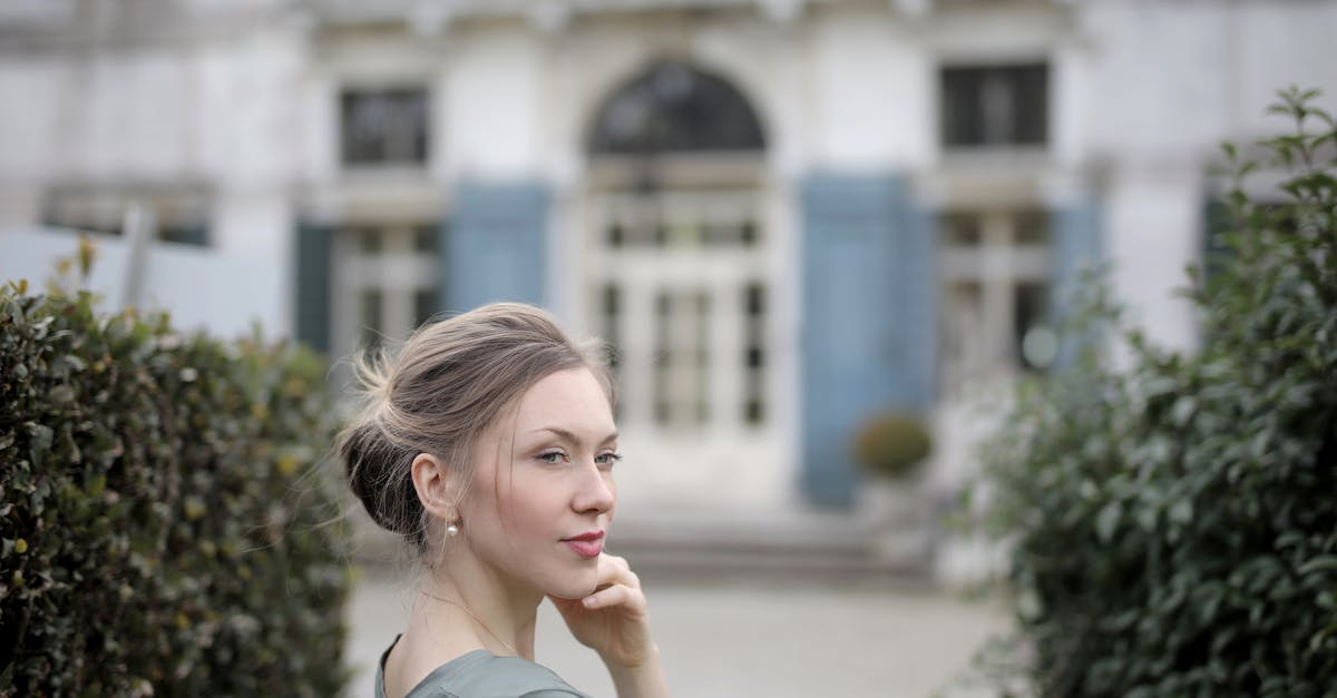 Old iPod that won't upgrade to iOS 7 [duplicate] - Thoughtful casual lady in gray t shirt with beautiful hairstyle posing and looking away while standing near old building between trimmed bushes of garden