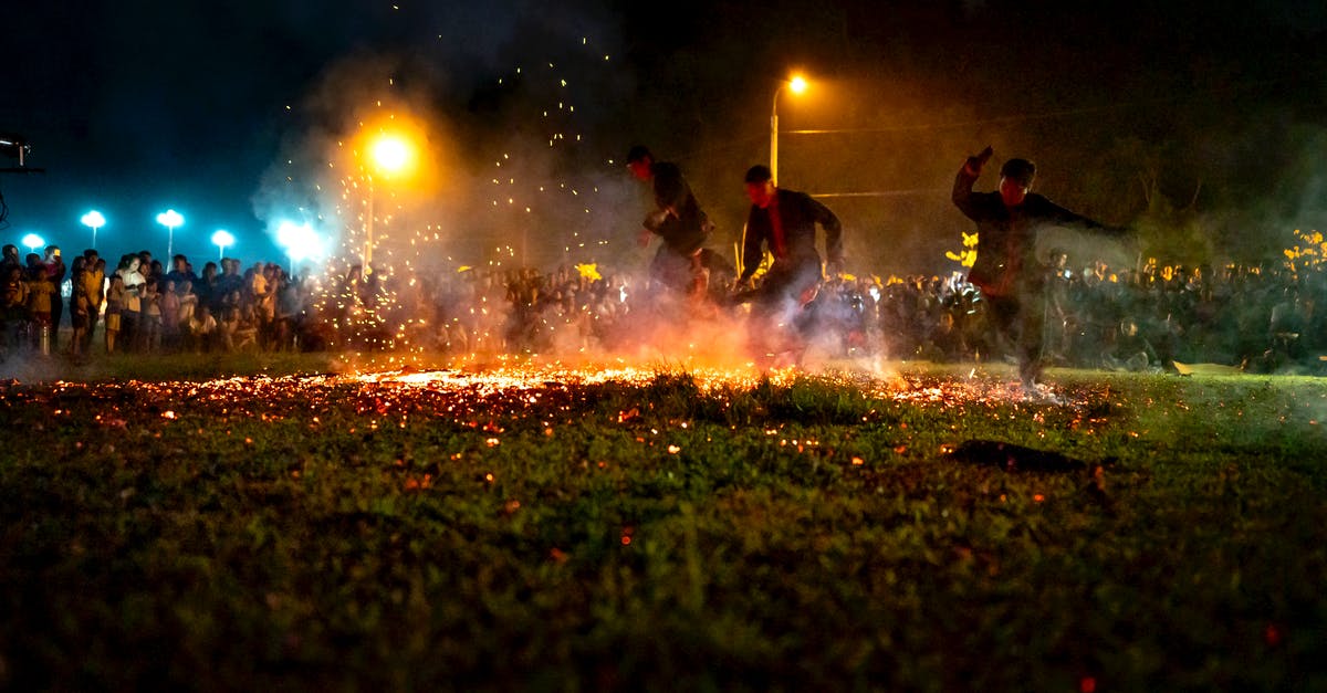 Older artifacts never showing in Temple Run 2 - Men in casual clothes running on hot burning coals placed on grass during night show