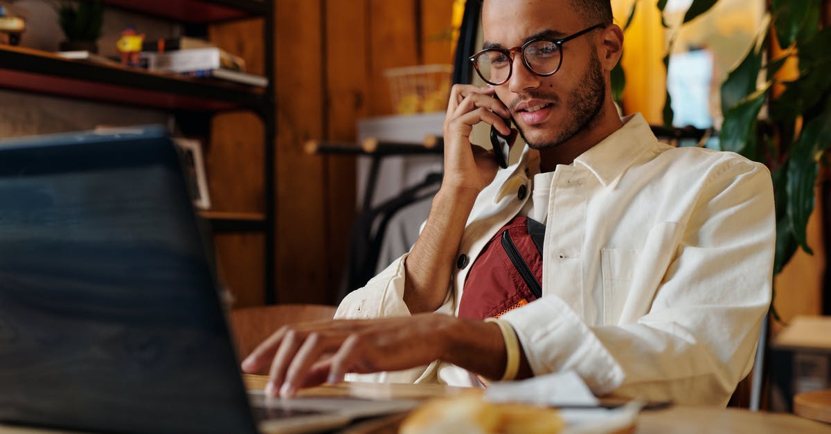 Online features ceased to work - Stylish Man in White Jacket and Eyeglasses having a Phonecall 