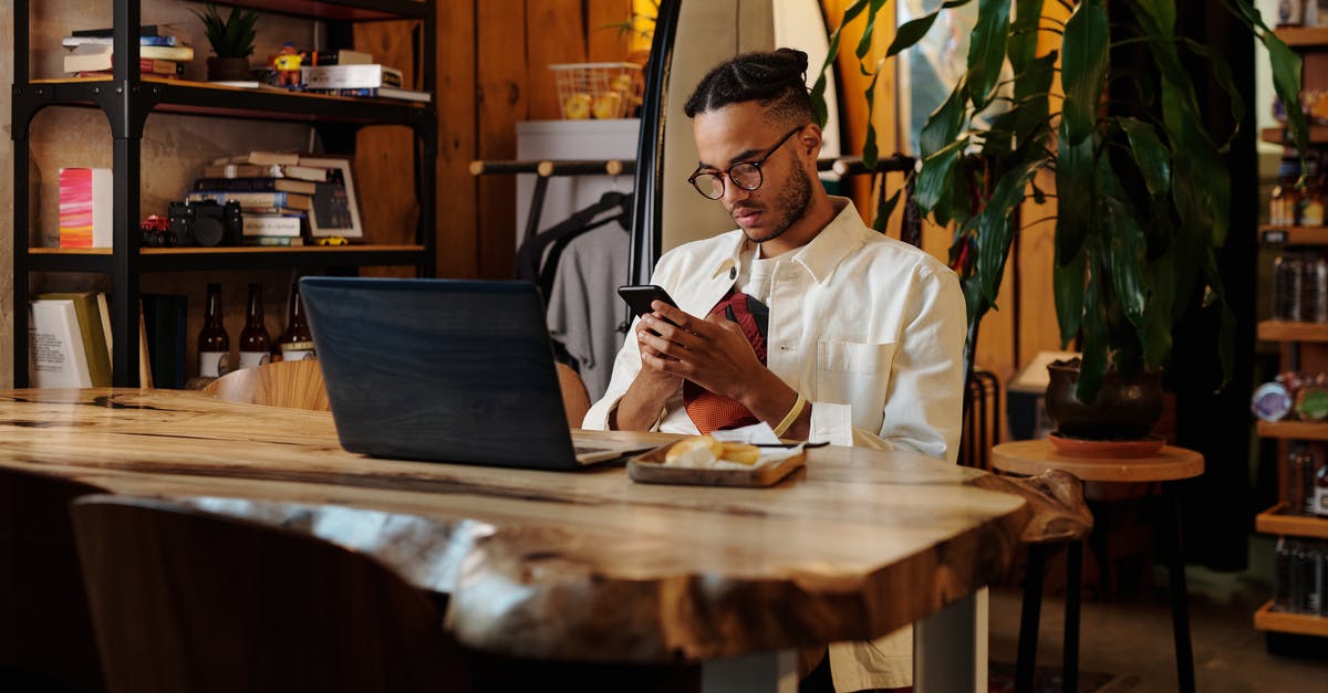 Online features ceased to work - Stylish Man in White Jacket and Eyeglasses using his Phone 