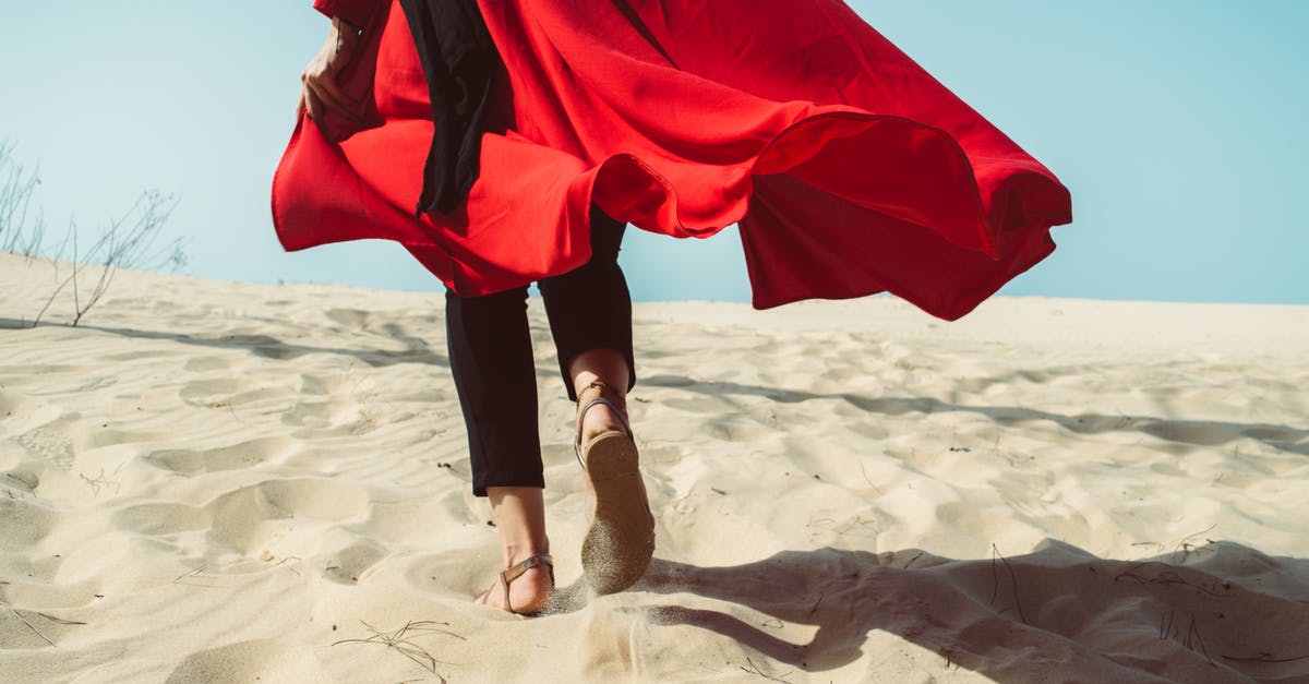 Outfit swap during exploration - Photo Of Person Walking On Sand 