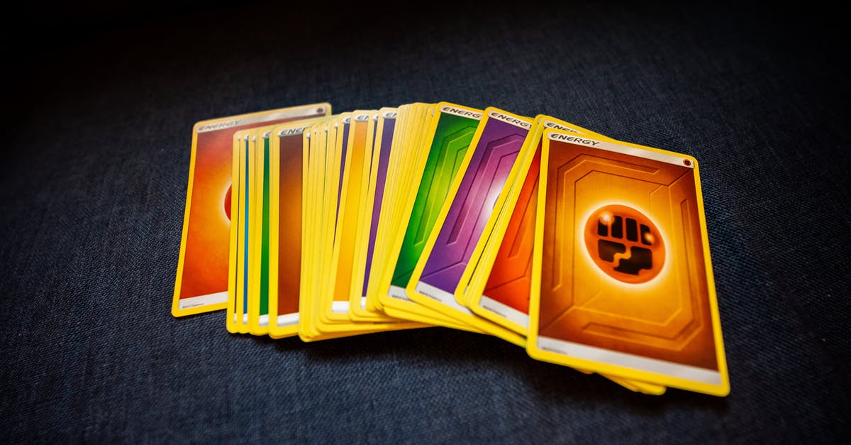 Playing An Item Card - From above of colorful pack of trading cards for game placed on gray surface