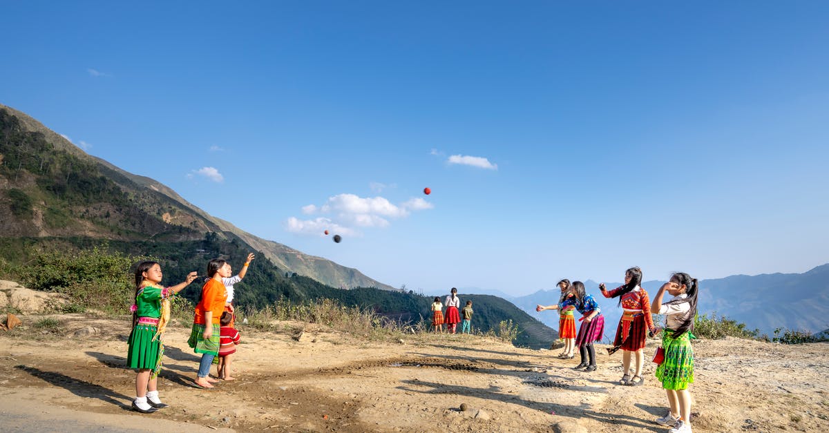 Pokemon Ultra Sun game restarts every time the game is played - Playful children in colorful clothes throwing balls to each other while standing near mountain ridge during game in sunny countryside