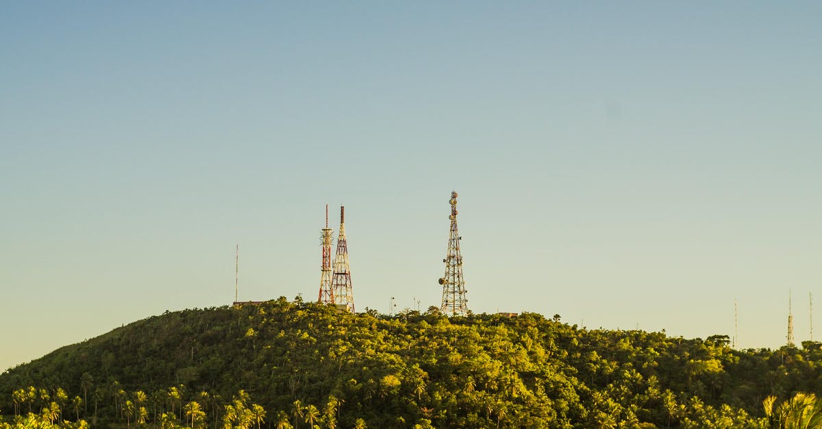 Polish tech tree, radio R-123 - Metal tall telecommunication towers on high hills covered with tropical trees with fresh verdant foliage under cloudless sky