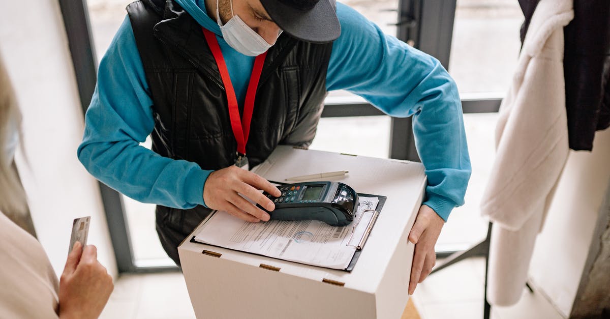 Portable DOSBox machine - Man in Blue Hoodie and Black Dawn Vest Holding Box