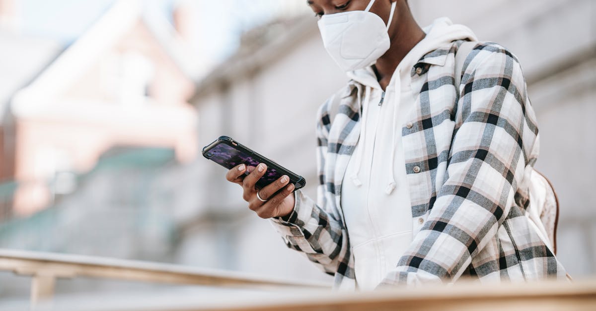 Prevent AI from using Venice - Black woman using smartphone on city street