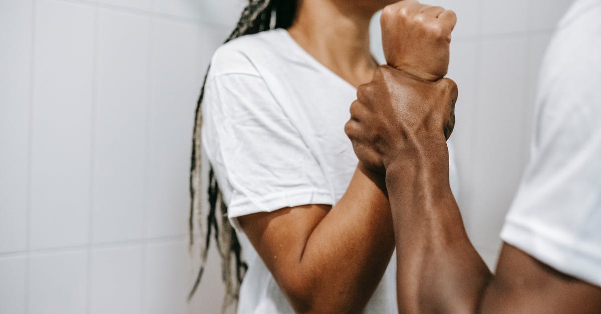 Problems with the Draug boss fight - Side view of crop unrecognizable aggressive African American male holding wrist of scared wife while quarreling together in bathroom