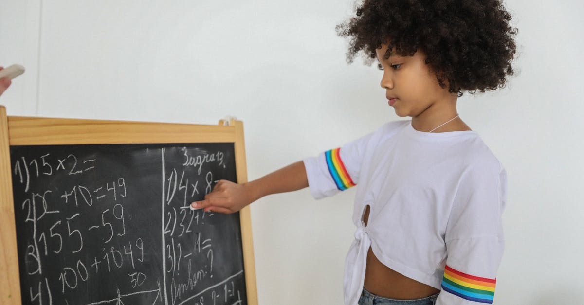 Recovering task points for Gil-farming Adamantoise - Side view of pensive black girl pointing at mathematical example on blackboard at light room in daytime