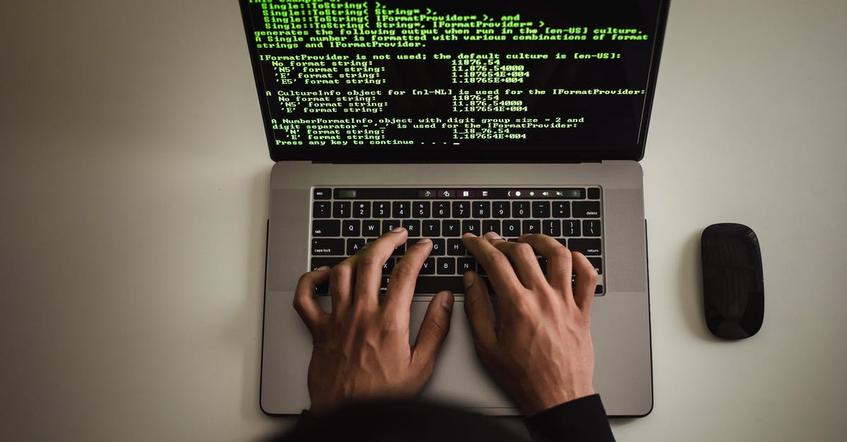 Retrieving code for Spore from 2010 - From above crop anonymous male programmer in black hoodie working on software code on contemporary netbook and typing on keyboard in workspace