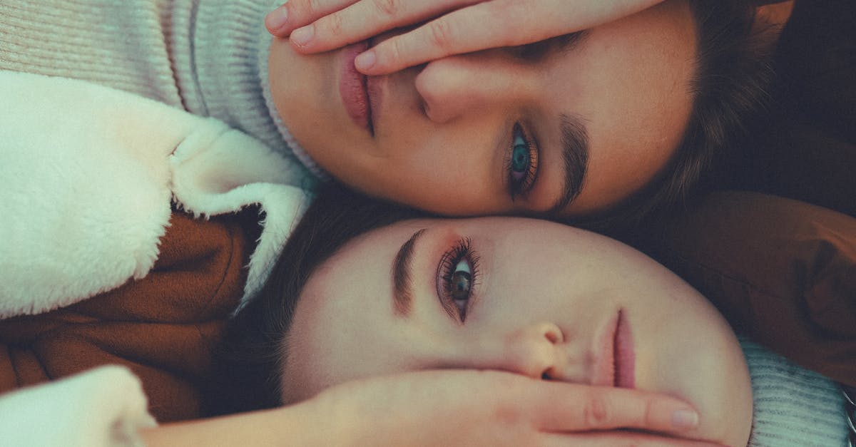 Ring of hircine and saviors hide - Top view of best female friends covering eye to each other while lying and looking at camera