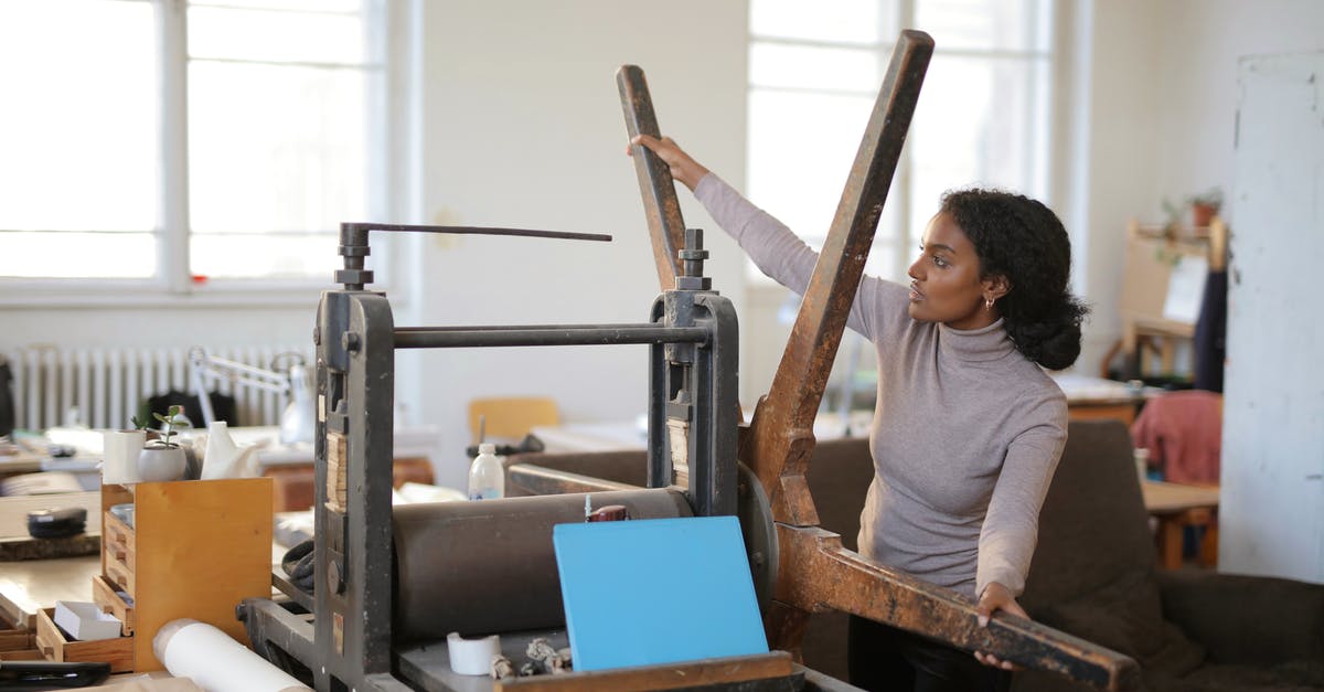 Safe to delete the workshop folder in Steamapps? - Serious African American employee taking wooden wheel of paper rolling machine while standing in workshop near paper roll in sunlight