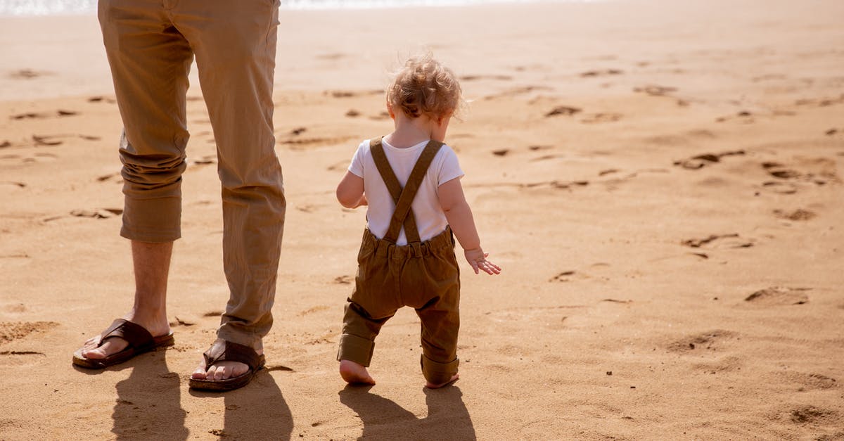 Send baby villagers through flowing water into soul sand elevator - Anonymous dad looking after small kid carefully stepping on sandy beach in sunny day