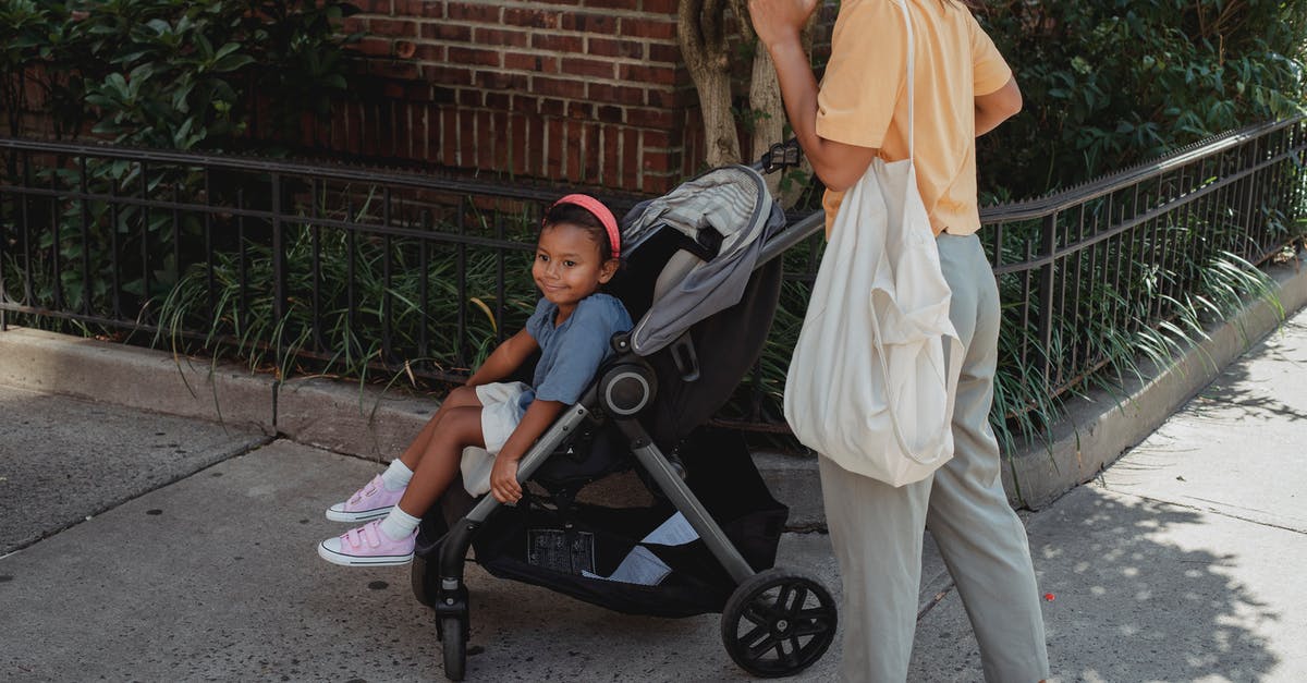 Should I call my mom? - Ethnic mother and daughter walking on street