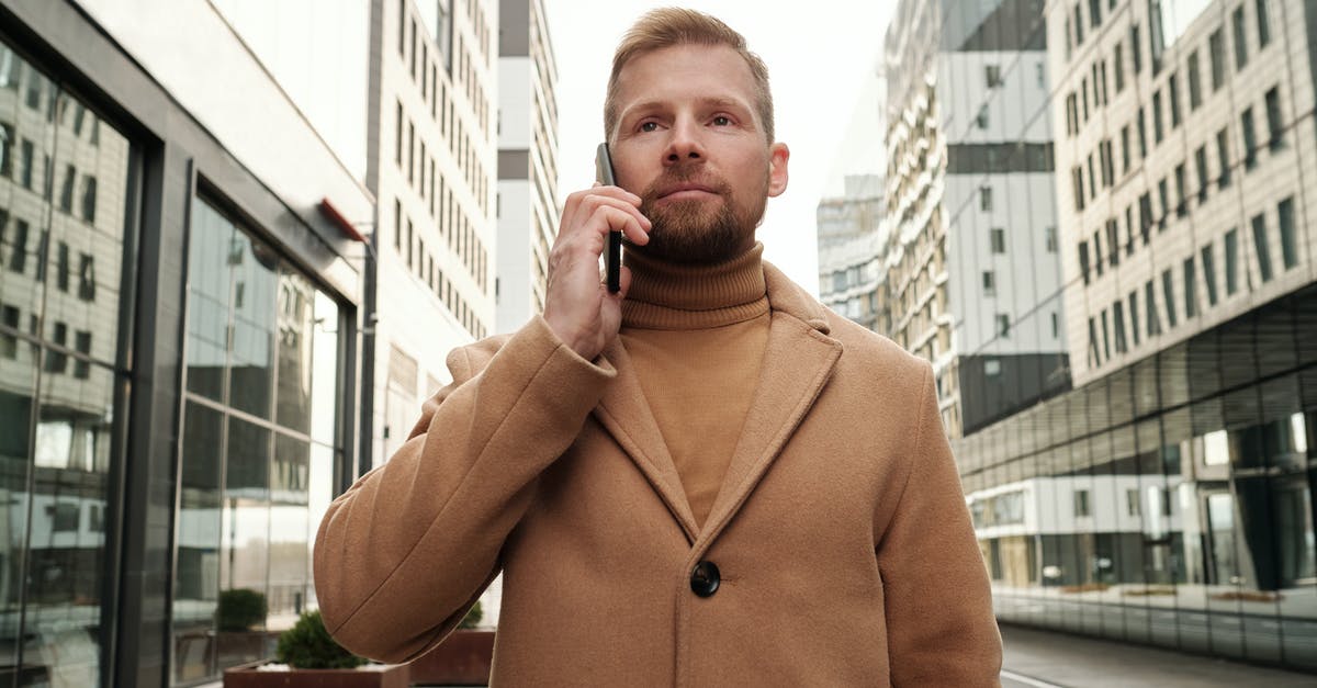 Should I call my mom? - Man in Brown Coat Standing Near Building