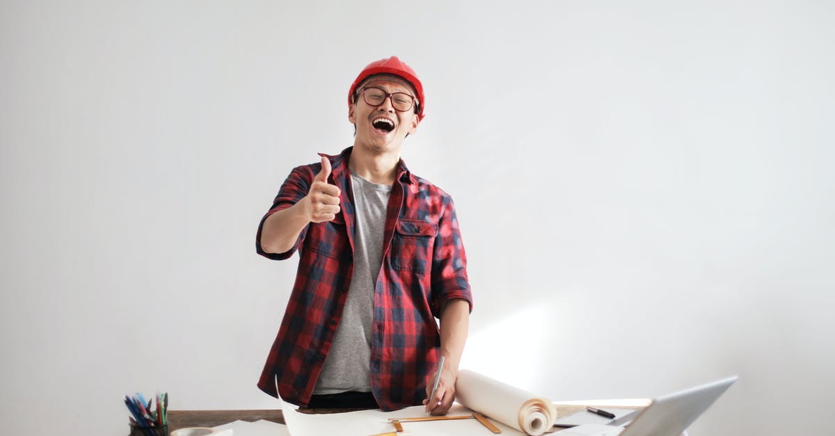 Specialist died before developing weapon - Laughing male constructor showing thumb up at working desk