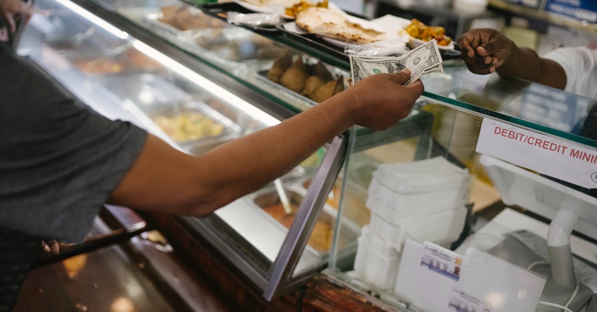 Steam Community market Buy Orders - Crop faceless person standing near checkout buying food and passes money for dinner in cafe