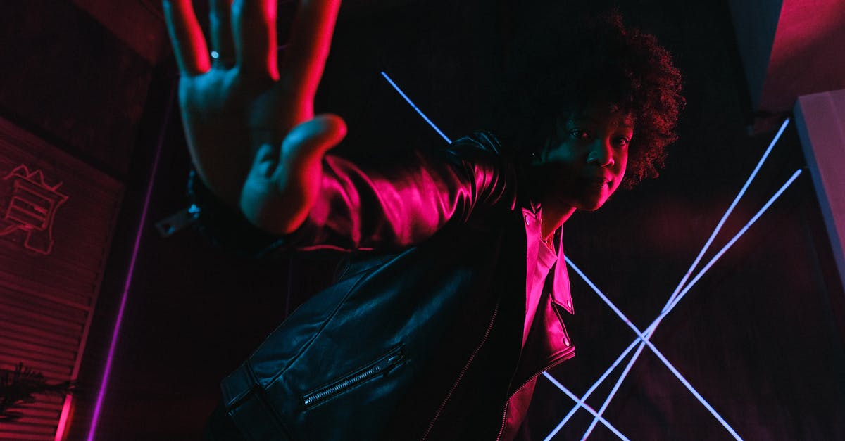 Stop yo weights from inducing chaos due to spinning without struts? - Low angle of trendy black female adolescent leaning forward while demonstrating control gesture and looking at camera against lamps at night