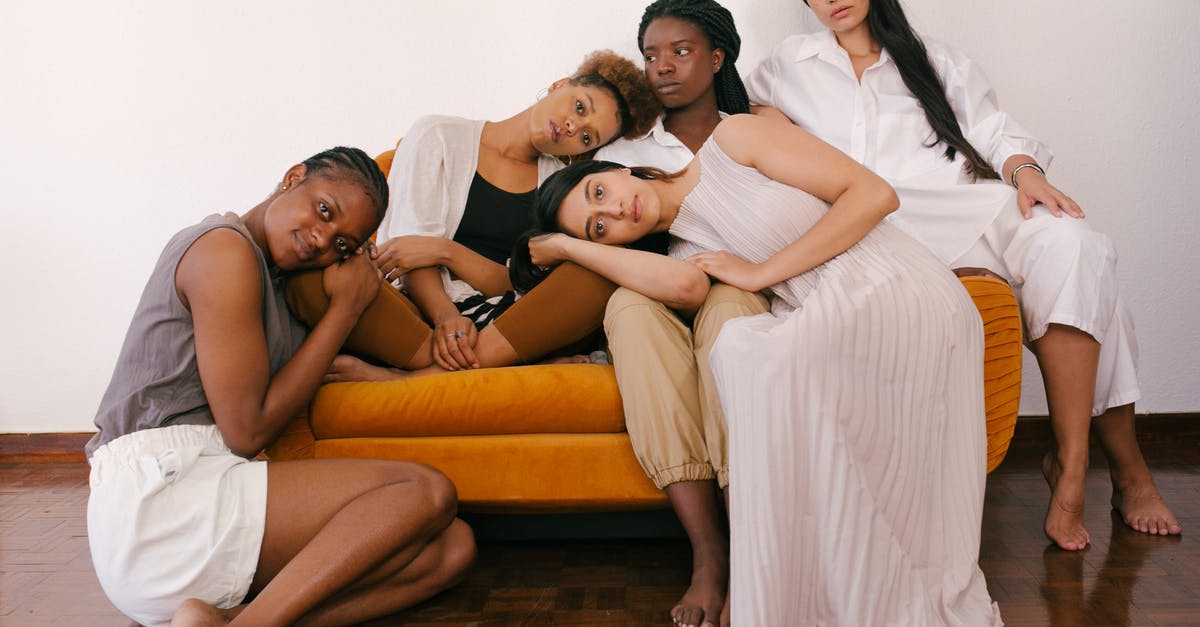 Stuck on a level for think different - Photo of Women Sitting on Orange Sofa