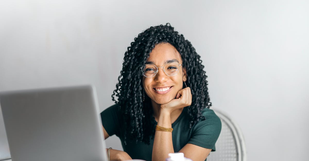 Super Secret Room with black poop and spikes - Happy ethnic woman sitting at table with laptop