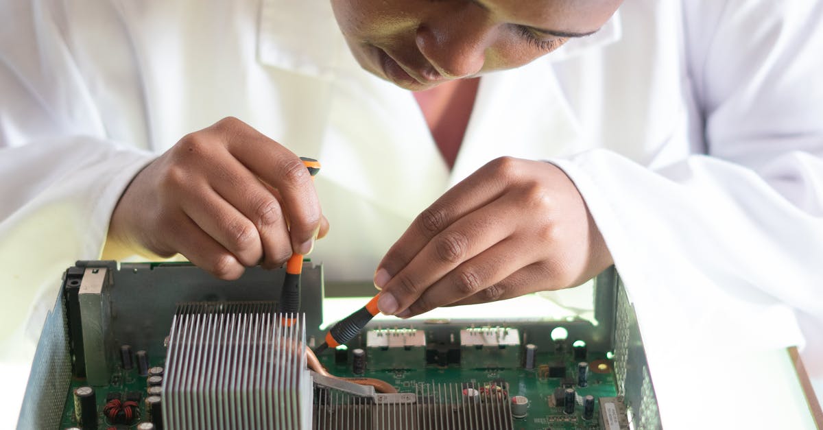 Test for range of values in a datatag using testforblock - Concentrated African American technician wearing lab coat and conducting expertise of motherboard by using screwdrivers while working in service center Test for range of values in a datatag using testforblock - Concentrated African American technician wearing lab coat and conducting expertise of motherboard by using screwdrivers while working in service center