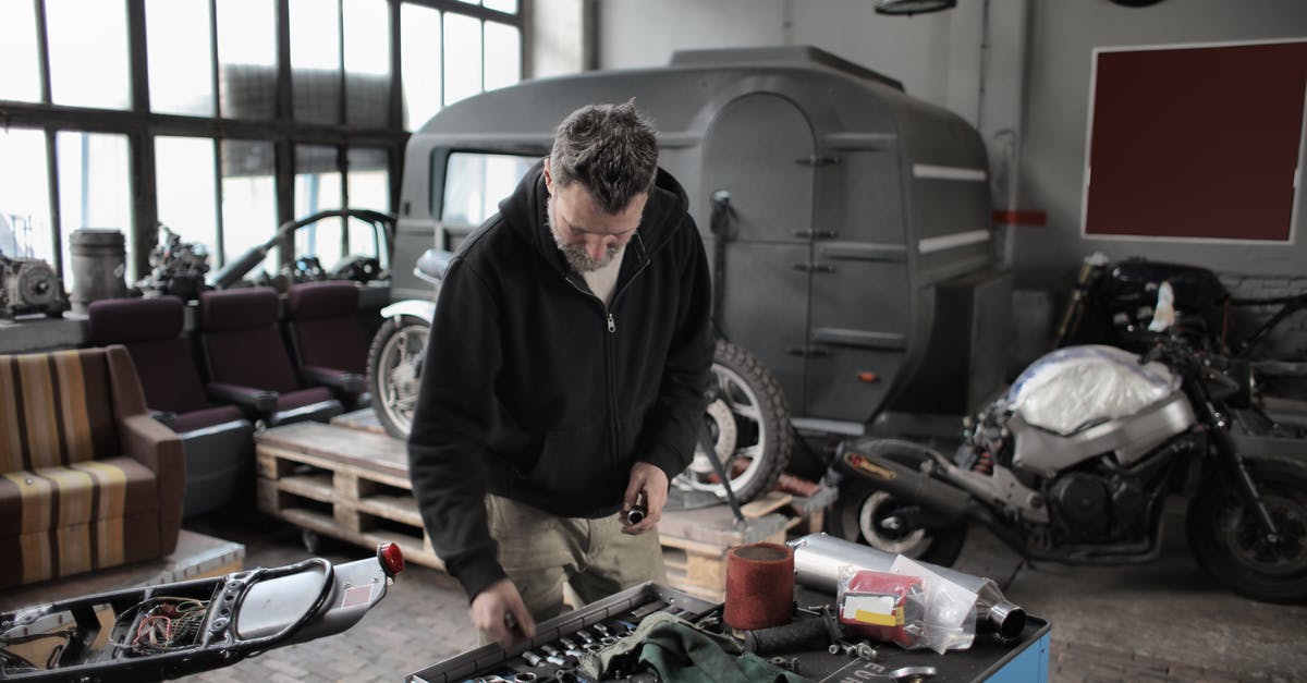 The Witcher I - Cannot beat Grand Master - Bearded adult mechanic in casual clothes checking tools while working with vehicle in workshop