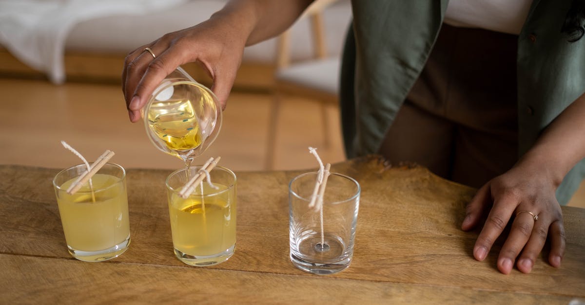 Transferring Xbox rewards - A Person Transferring Candle Wax on an Empty Glass Bottle