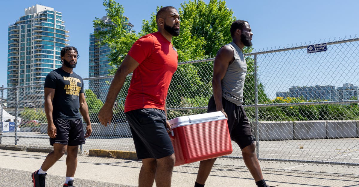 Troops walking out on me - Men in Sportswear Carrying a Cooler while Walking