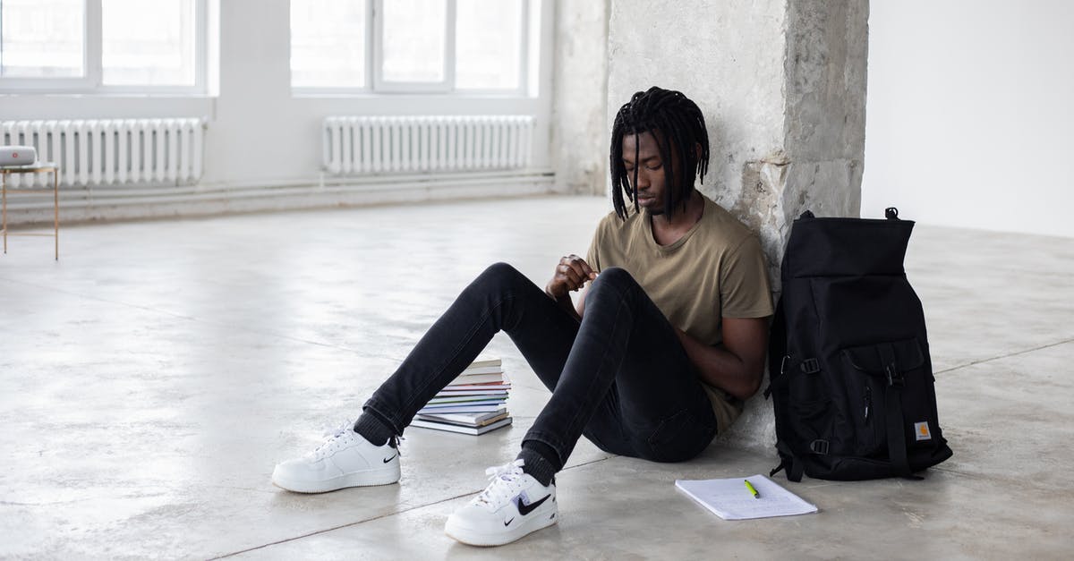 Trouble with Guard Break - Full body of upset African American man sitting among textbooks and notebook near backpack during break in exam preparation