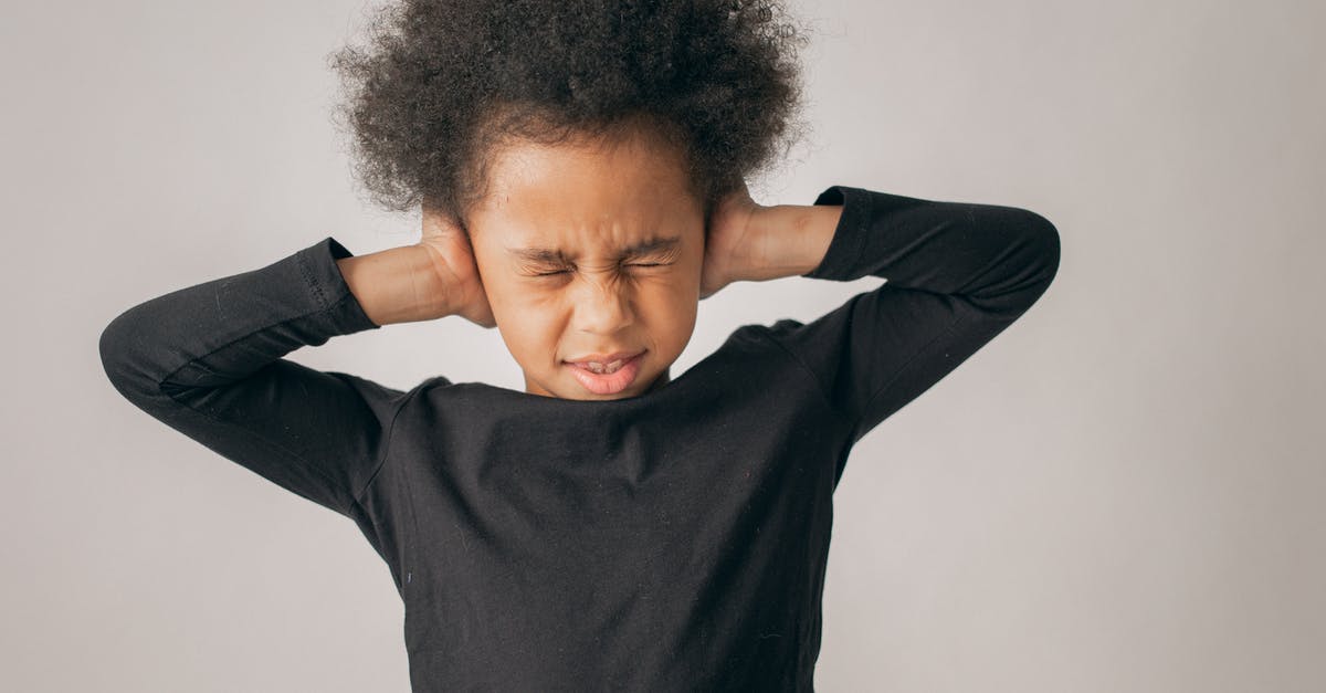 Trouble with mouse sensitivity lagging on older version of Minecraft - Unhappy African American girl with Afro hairstyle covering ears while standing on white background with closed eyes in light studio