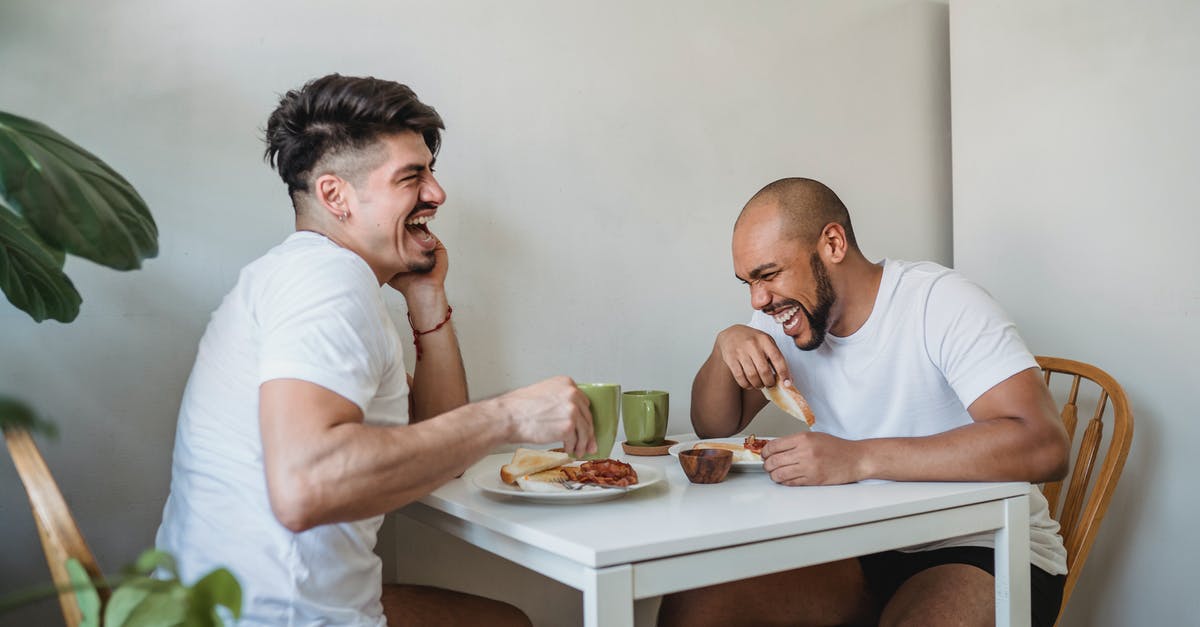 Two rivals having a mutual ally - Two Friends Sitting at Table and Having Fun at Breakfast