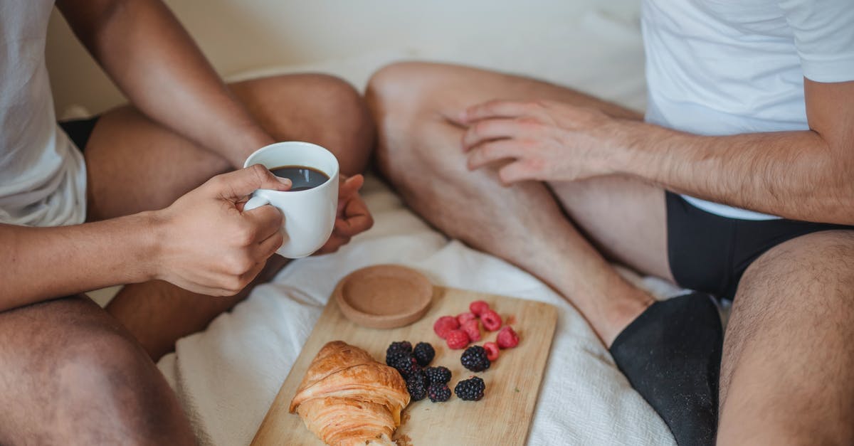 Two rivals having a mutual ally - Two Unrecognizable Men Sitting on Bed and Having Breakfast