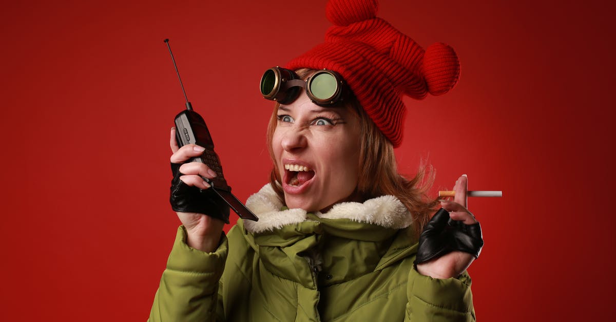 Using Carnage to generate Rage with weapons other than the Chaoseater - Annoyed female model in outerwear with old goggles yelling into walkie talkie while looking away on red background