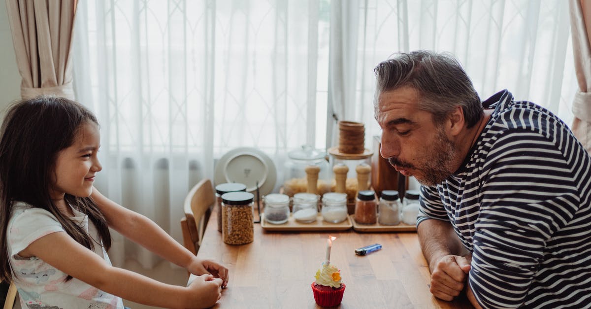 Vertical redstone crossroads - Father with Daughter at Kitchen Table Blowing out a Candle on a Cupcake