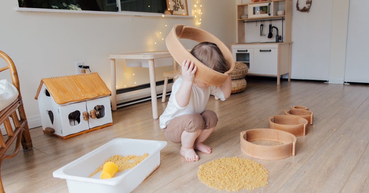 Warcraft 3 LAN Game discovery - Full length of anonymous toddler squatting barefoot on floor playing with round wooden shapes of different size and pasta and putting biggest shape on while developing fine motor skills at home