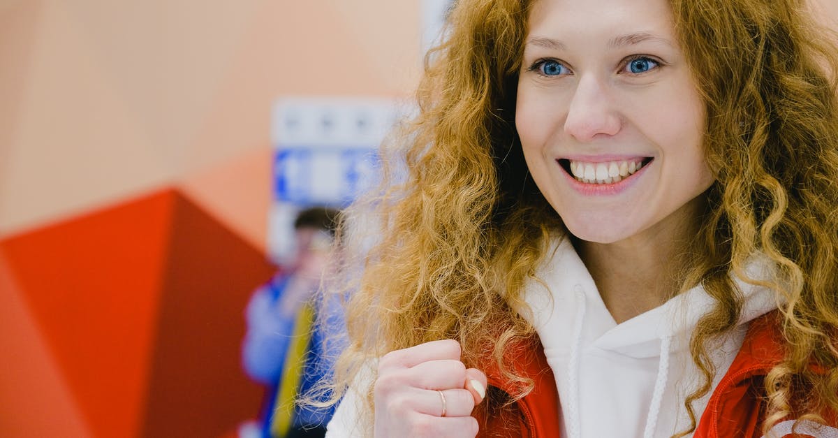 What's going on inside the game when a BUD switch activates? - Gleeful sportswoman with curly hair in sportswear cheering for team with clenched fists and looking away while standing in arena during curling game