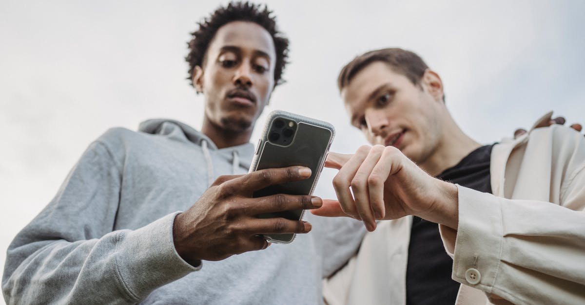 What's the point in scouting low level players? - Multiethnic friends browsing smartphone together outside