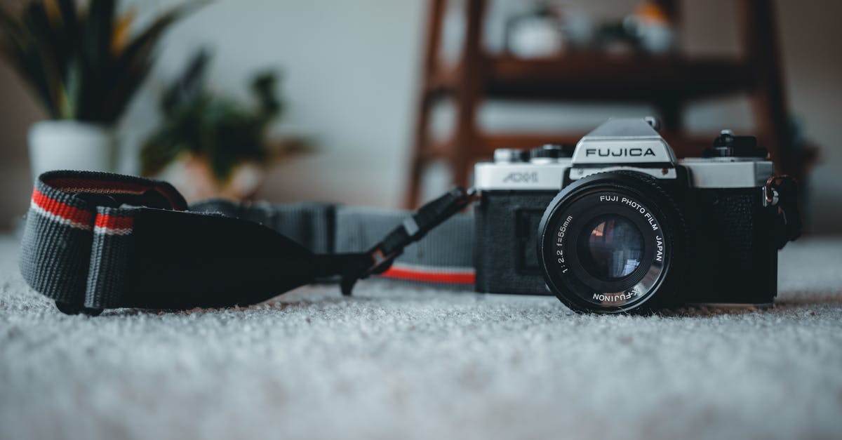 What are all item level thresholds that increase Una's task rewards? - Ground level of old fashioned photo camera with lens and black strap placed on rug in room with flowerpots and wooden shelf on blurred background