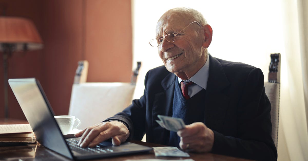 What are the additional privileges earned by an elder? - Positive senior businessman typing on laptop while holding money in hand