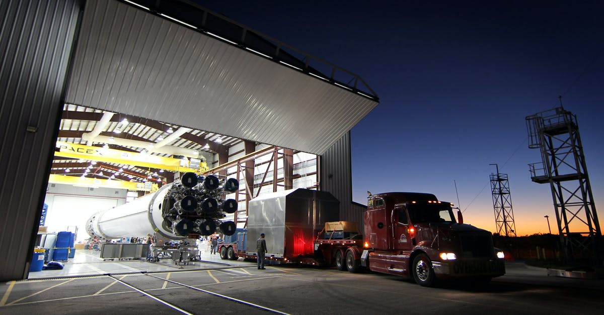 What are the benefits of having a cargo freight station? - Truck parked near hangar in rocket factory