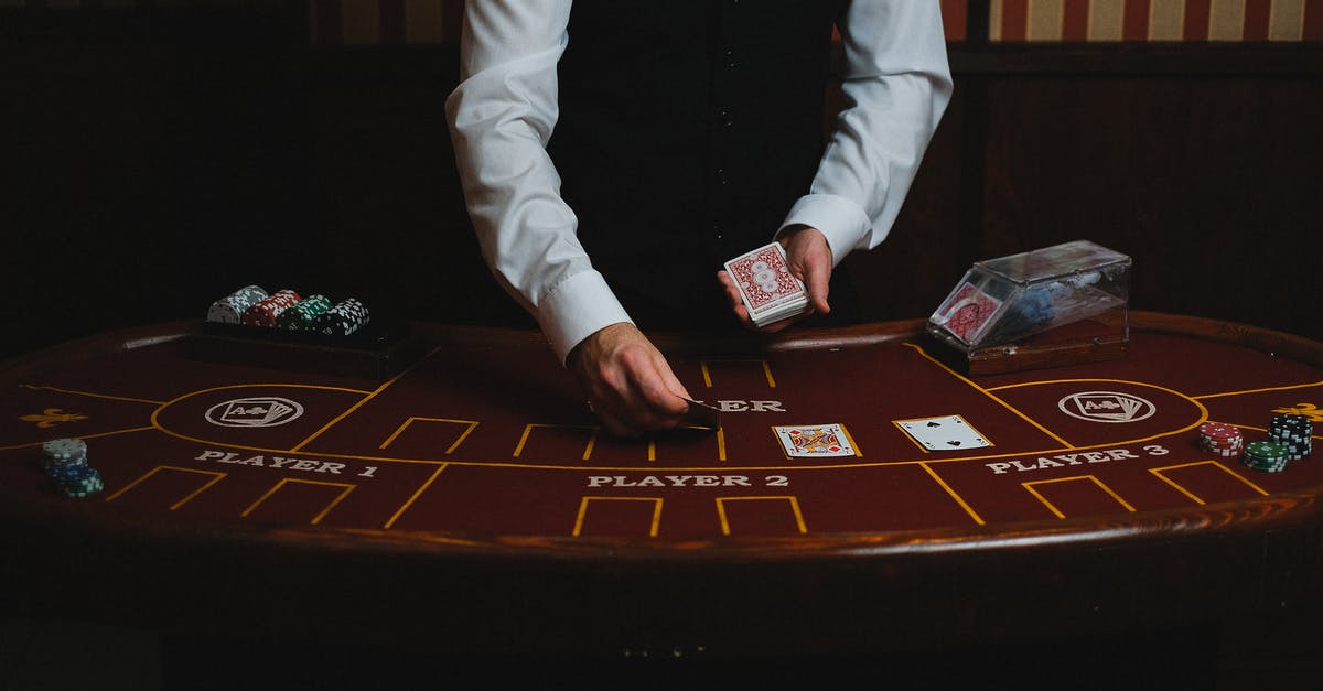 What are the chances of getting a legendary card? - Man in White Suit Jacket Sitting Beside Brown Wooden Table