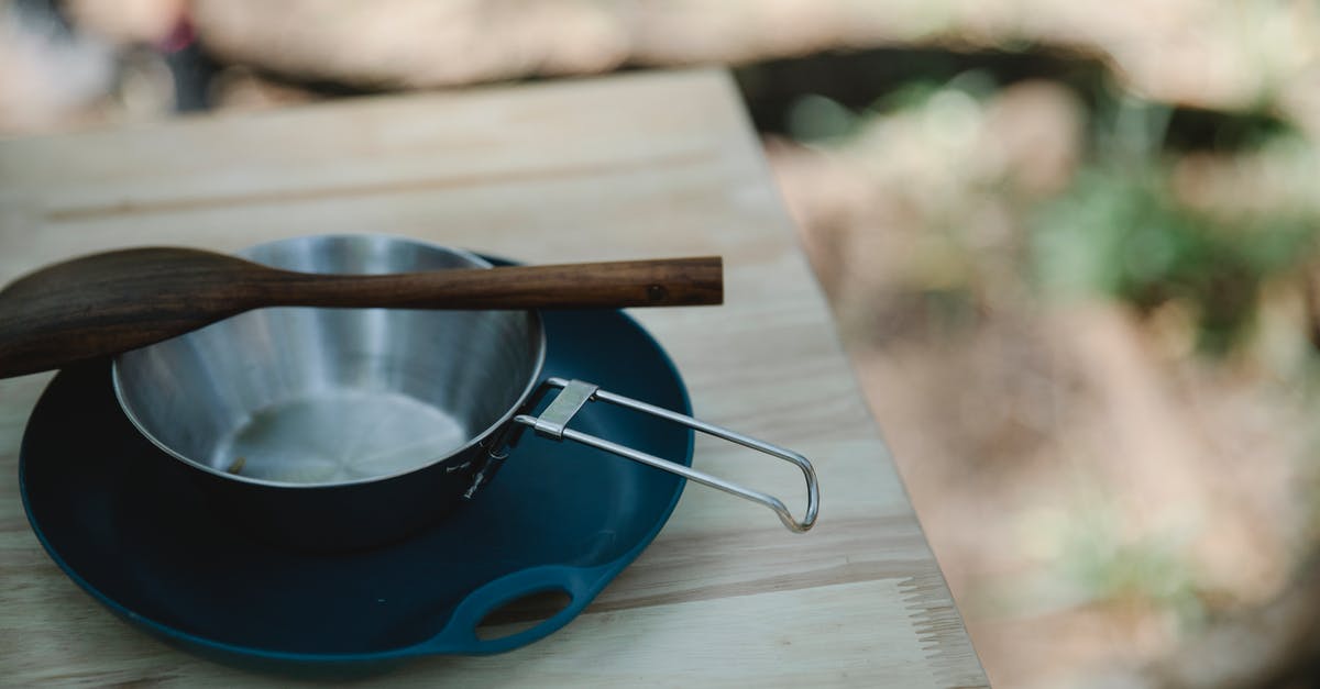 What are the different tiers of gear mods? - High angle of metal pan and wooden spatula placed on plastic plate on table