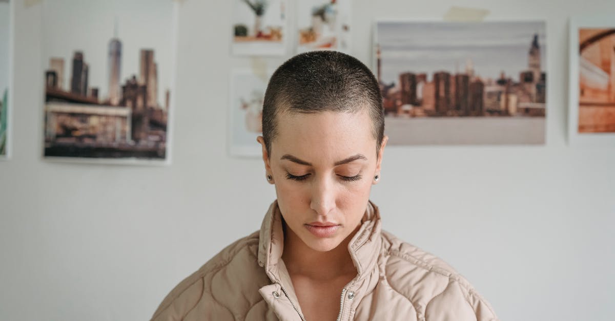 What are the effects of the various Protectron Personality Modes? - Short haired serene female with makeup looking down against decorative images hanging on white wall