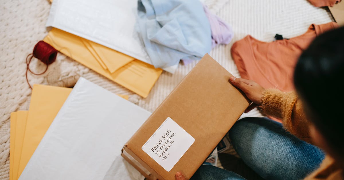 What are the names of all the ships? - Top view of crop anonymous female with carton box of parcel checking address among envelopes