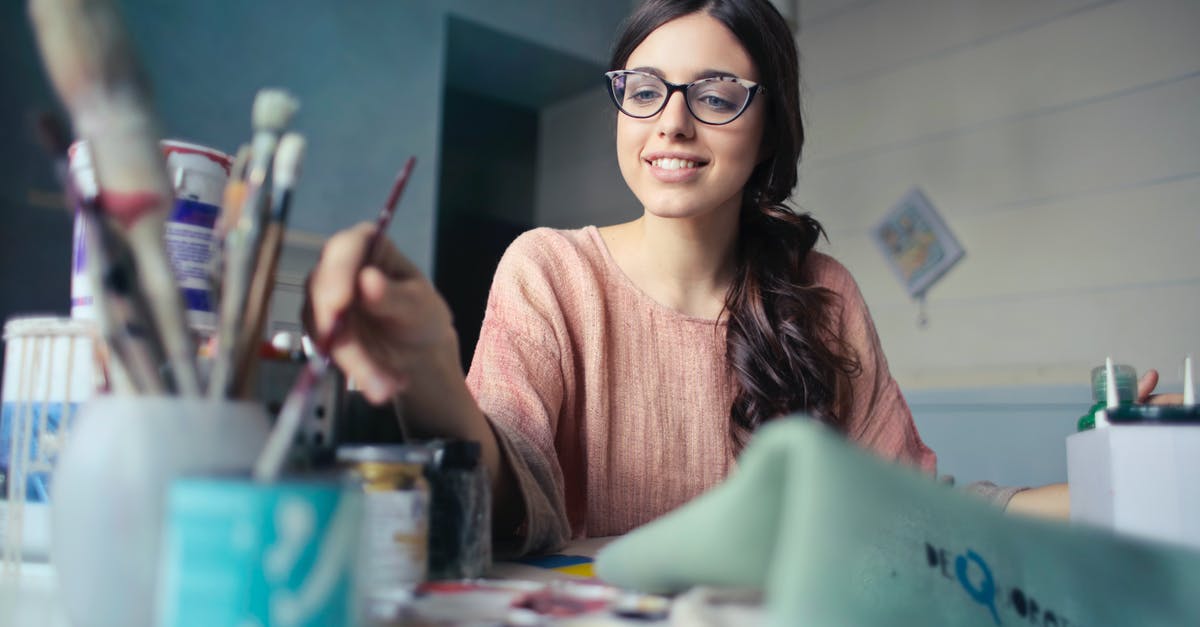 What are the phrases that I can paint? - Woman in Brown Long-sleeved Shirt Wearing Eyeglasses Holding Paint Brush