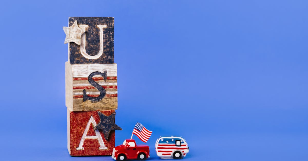 What are these lettered blocks? - Toy Scale Model With American Flag Beside Wooden Blocks With Letters