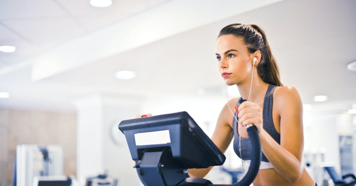 What determines my post-raid health status after not escaping Tarkov? - Serious fit woman in earphones and activewear listening to music and running on treadmill in light contemporary sports center