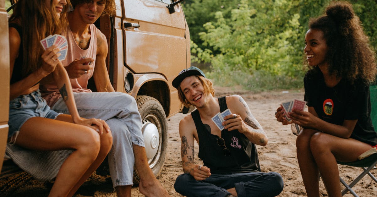 What do the playing cards do in the binding of isaac? - Friends Playing a Card Game outside Their Camper Van