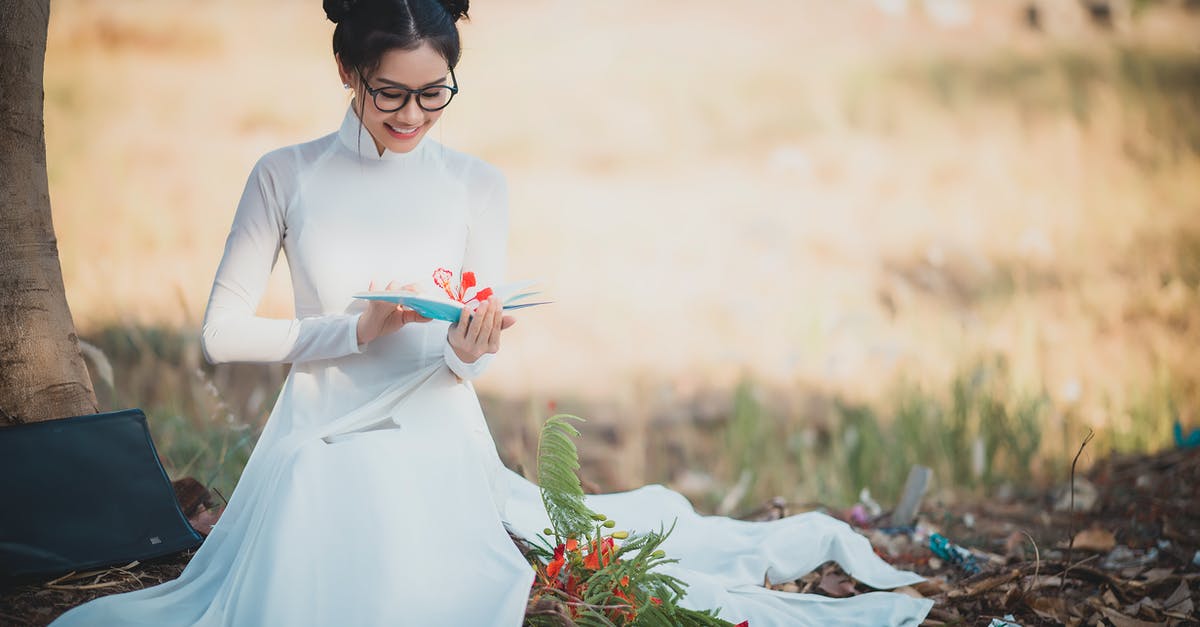 What does AoS mean? - Woman in White Long Sleeve Dress Holding Red Flower