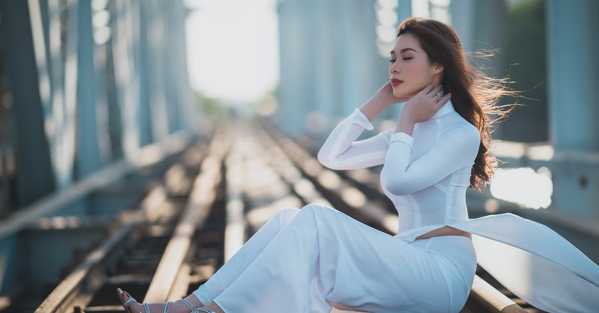 What does AoS mean? - Woman in White Long Sleeve Shirt and Blue Pants Sitting on Brown Wooden Bench